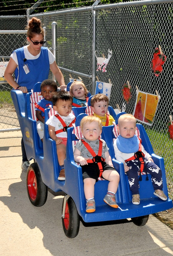 Katelyn Brusso, a staff member at DLA’s Fort Belvoir, Virginia, Child Development Center, takes children on a short journey during a Book Walk featuring “Pete the Cat and His Very White Shoes” in May 2018.