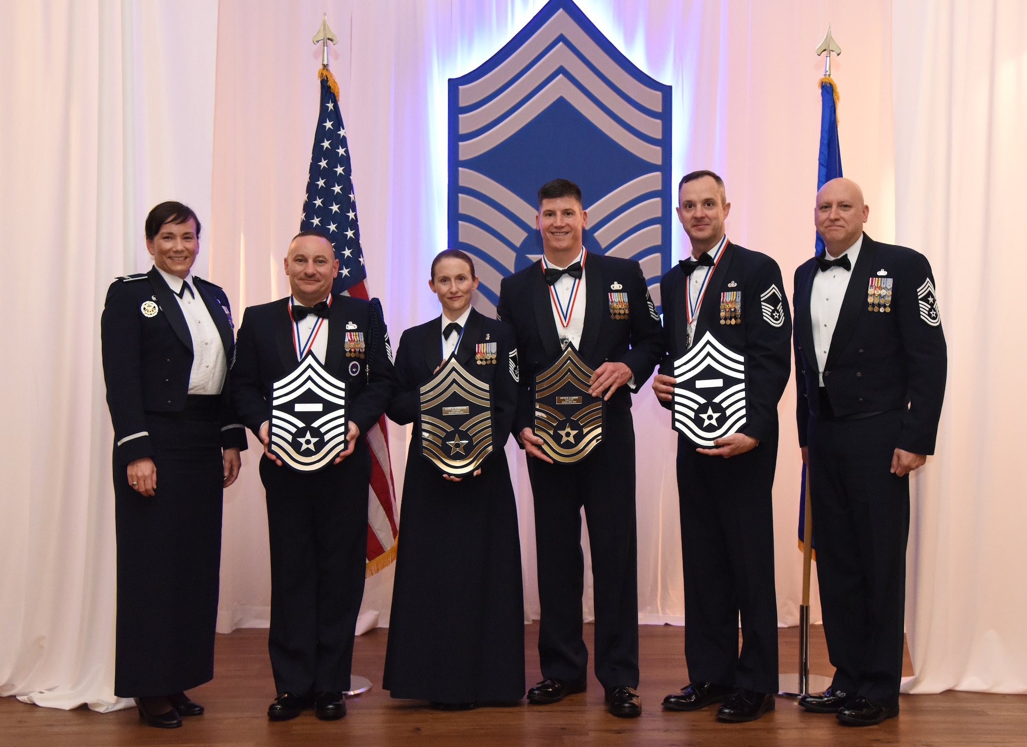 Leadership from the 81st Training Wing poses with Keesler's newest chief master sergeants holding plaques displaying their line numbers during the Chief Induction Ceremony inside the Bay Breeze Event Center at Keesler Air Force Base, Mississippi, Feb. 15, 2019. Five Keesler Airmen earned their chief master sergeant stripe during the 2019 promotion release. Air Force officials selected 479 senior master sergeants for promotion to chief master sergeant out of 2,241 eligible for a selection rate of 21.37 percent. Chief master sergeants make up one percent of the Air Force enlisted force. (U.S. Air Force photo by Kemberly Groue)