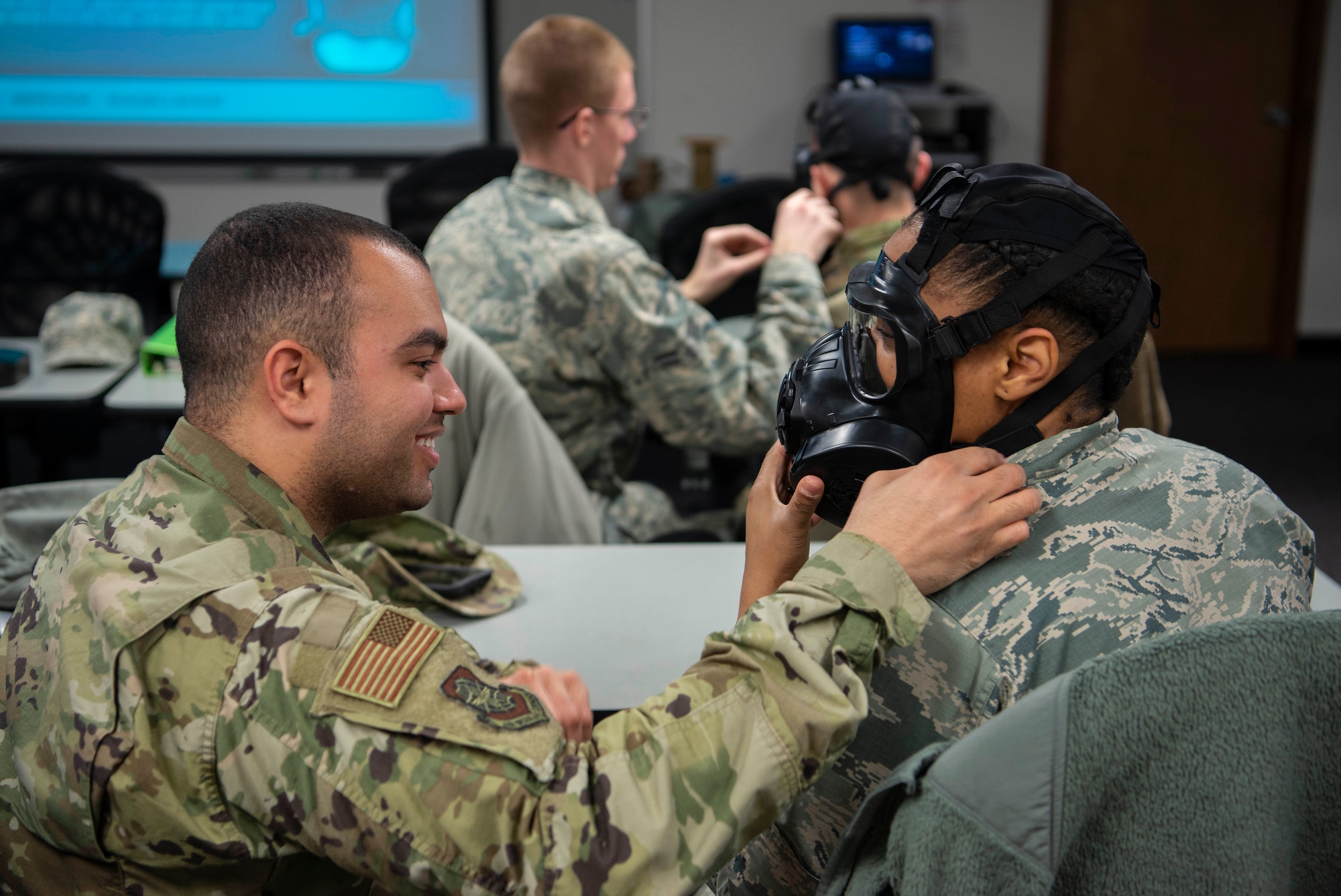 Staff Sgt. Matthew Benassi, 375th Logistics Readiness Squadron fuels service center supervisor, helps 1st Lt. Brittnie Davis, 375th Air Mobility Command intelligence officer, fit her M50 gas mask properly to her head and face during Chemical, Biological, Radiological and Nuclear training Feb. 7, 2019, at Scott Air Force Base, Illinois. Fitting the mask before having to use it makes the process of putting it on easier, if needed, in life-threatening situations. The mask protects against potential toxins in the air that can quickly spread causing health issues or even death. (U.S. Air Force photo by Airman 1st Class Miranda Simpson)