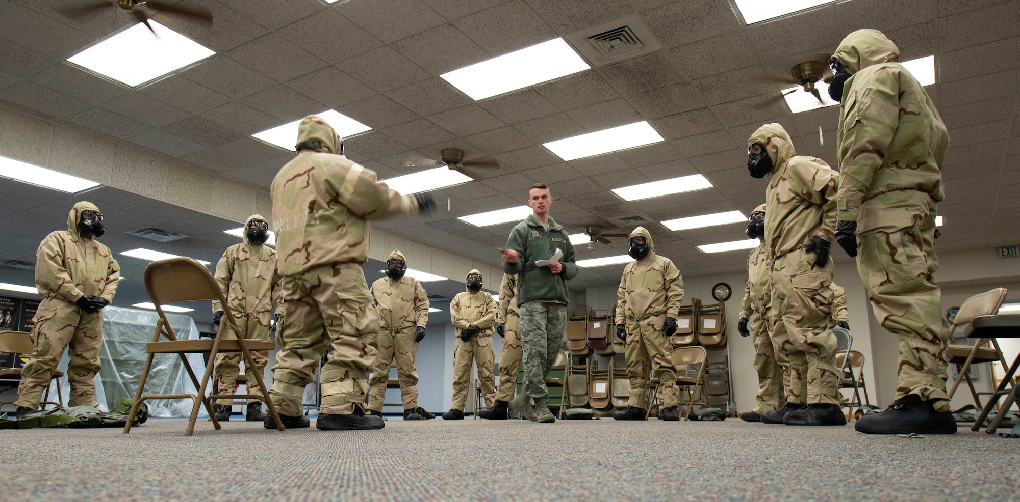 Airman 1st Class Carson St Andrews, 375th Civil Engineer Squadron emergency management technician, instructs Airmen how to remove their Mission Oriented Protective Posture gear during a Chemical, Biological, Radiological and Nuclear training class Feb. 7, 2019, at Scott Air Force Base, Illinois. There are precise steps to remove the gear to prevent the spread of contamination that may have accumulated on the outer wear during an attack or training environment. (U.S. Air Force photo by Airman 1st Class Miranda Simpson)