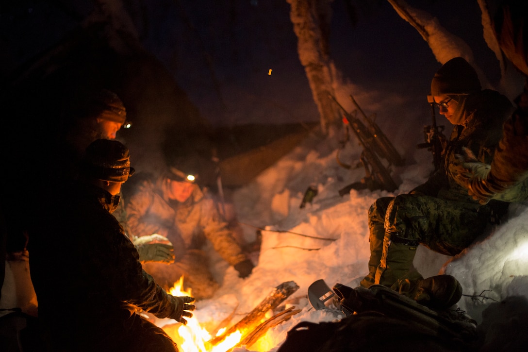 Marine huddle around campfire