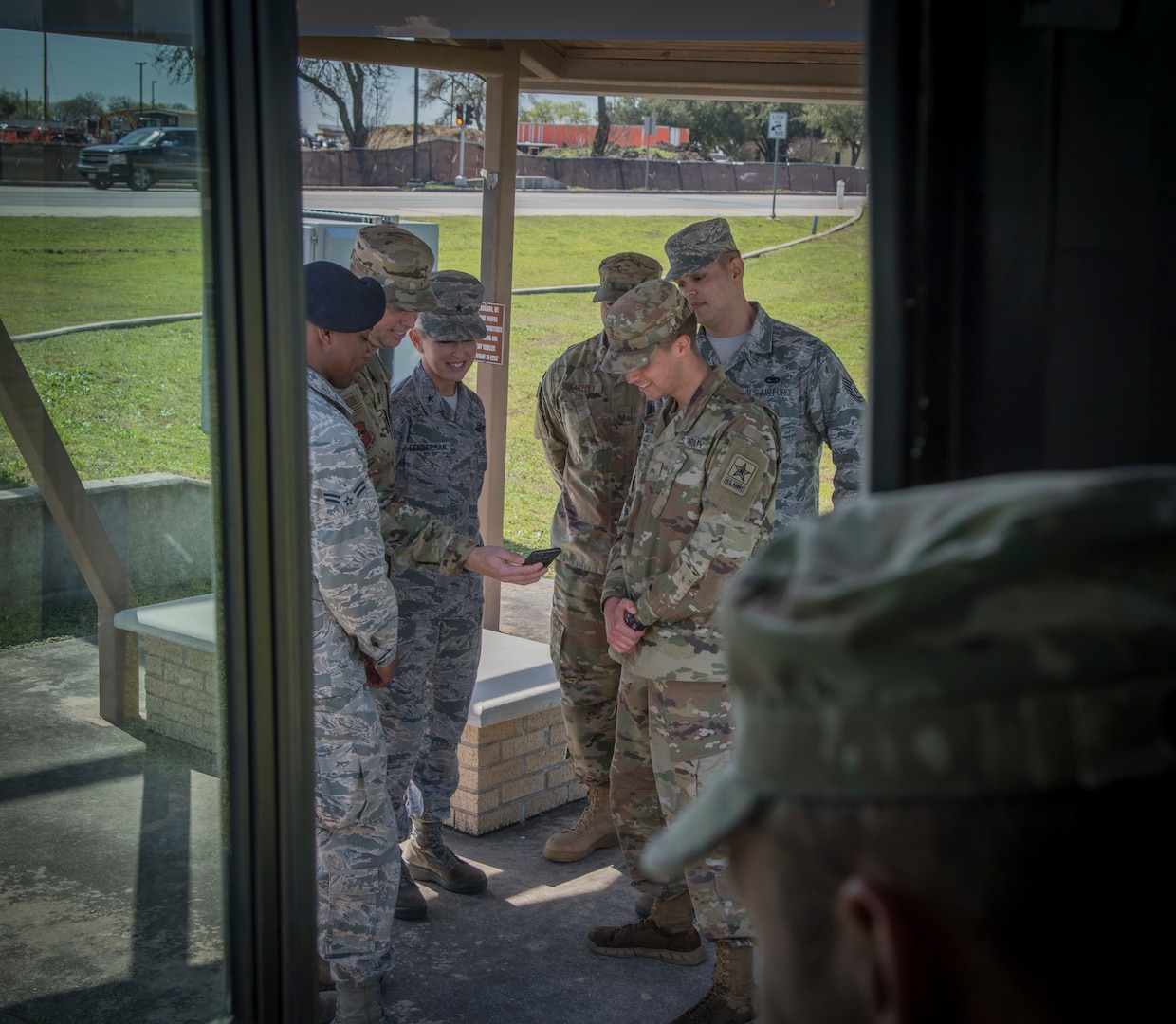 Chief Master Sgt. Christopher Lantange, Joint Base San Antonio command chief, showcases the “Ride Systems” application for JBSA shuttles to Brig. Gen. Laura Lenderman, 502d Air Base Wing and JBSA commander and other uniformed members at a JBSA-Lackland bus stop Feb. 20, 2019.  The app includes Global Positioning System tracking capabilities with mapping and coordination with the ground transportation offices to track exactly where each bus is, their route and how long the wait time is.