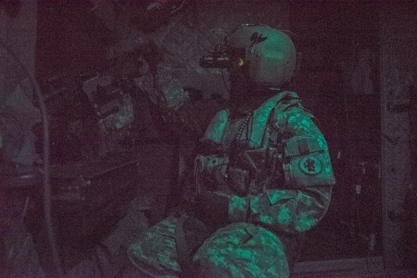 A U.S. Soldier sits behind an M-240H Machine Gun inside a CH-47 Chinook during aerial gunnery training in Belize, Feb. 11, 2019.