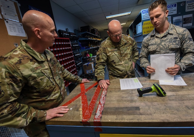 Chief Master Sgt. Daniel C. Simpson, left, 18th Air Force command chief master sergeant, Maj. Gen. Sam C. Barrett, center, 18th Air Force commander, and Senior Airman Jacob Wuerth, right, 437th Aircraft Maintenance Squadron aerospace maintenance apprentice, discuss the way Wuerth’s unit has streamlined the tool tracking process Feb. 13, 2019, at Joint Base Charleston, S.C.