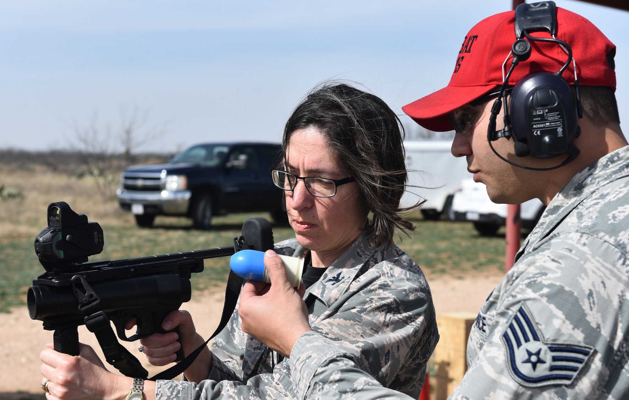 U.S. Air Force Col. Janet Urbanski, 17th Medical Group commander, receives coaching from Staff Sgt. Nestor Reyes II, 17 Security Forces Squadron combat arms instructor, during a demonstration at the San Angelo Police Department firing range, Texas, Feb. 15, 2019. Nestor explained the purpose of the sponge round and how it could be used during an altercation. (U.S. Air Force photo by Airman 1st Class Isiah Jacobs/Released)