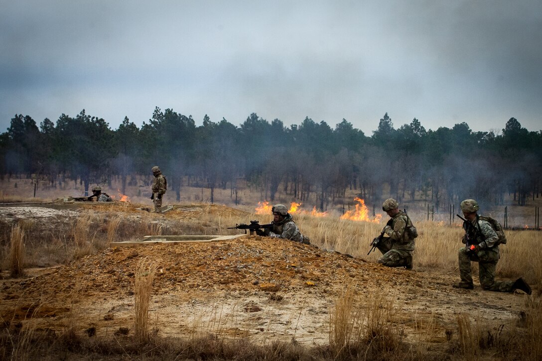 Service members shoot at targets.