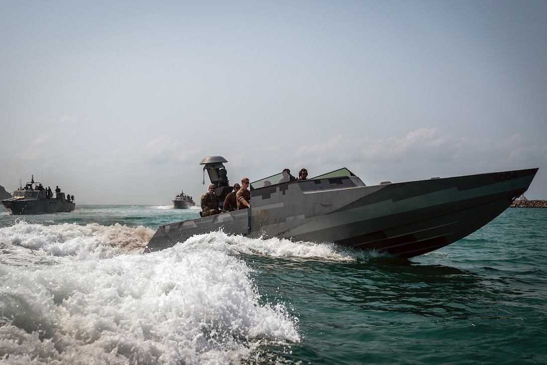 U.S. and Thai navy SEALs conduct an exercise on boats.