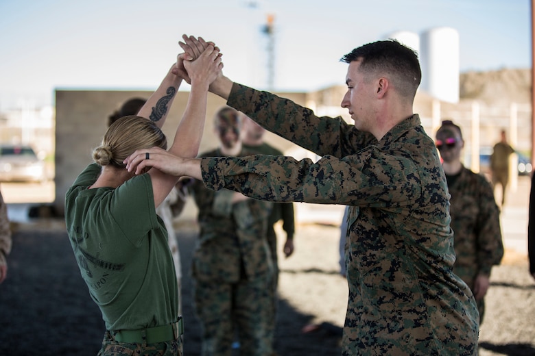 U.S. Marines assigned to Marine Aviation Logistics Squadron (MALS) 13 and their spouses participate in Jane Wayne Day at Marine Corps Air Station (MCAS) Yuma Jan. 25, 2019. Jane Wayne Day consisted of applying camouflage paint, getting some "drill instructor time", conducting a modified combat fitness test (CFT), going through the Obstacle Course, learning a few Marine Corps Martial Arts Program (MCMAP) techniques, and shooting the Beretta M9 Pistol. Jane Wayne Day is designed to give the spouses a little insight on some of the things their Marine does while having fun. (U.S. Marine Corps photo by Cpl. Sabrina Candiaflores)