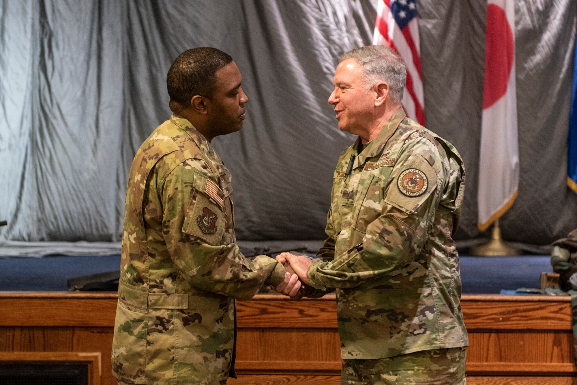 Maj. Gen. Steven A. Schaick, U.S. Air Force Chief of Chaplains, right, shakes hands with Col. Otis C. Jones, 374th Airlift Wing commander, left, immediately following the 2019 National Prayer Breakfast at Yokota Air Base, Japan, Feb. 21, 2019.