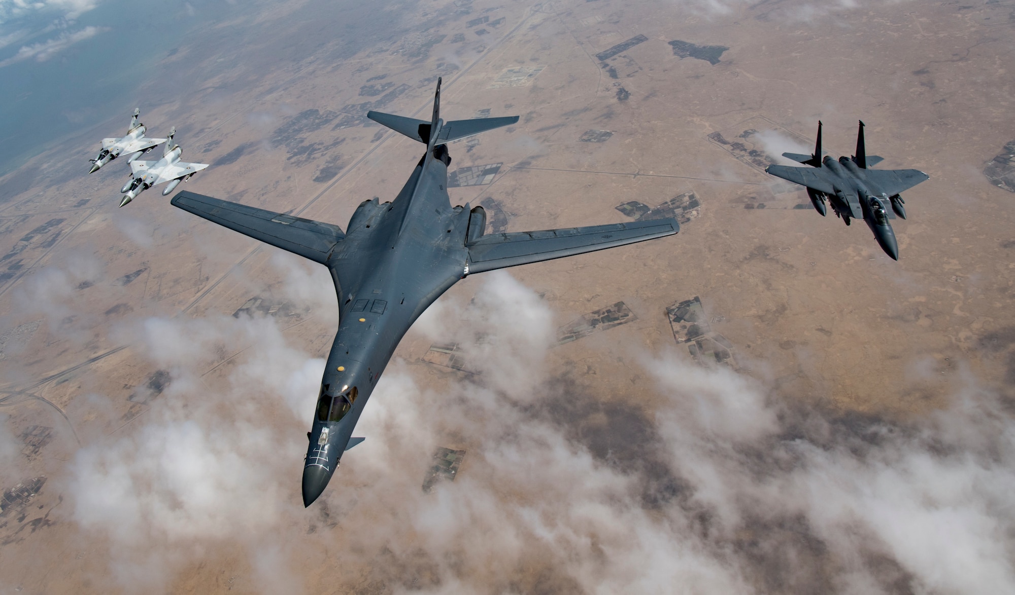 Qatari Mirage 2000s, a U.S. Air Force B-1B Lancer bomber and an F-15E Strike Eagle fly in formation during Joint Air Defense Exercise 19-01, Feb. 19, 2019. The aircraft and crews participated in the exercise together to test objective-based command and control during the exercise. (U.S. Air Force photo by Staff Sgt. Clayton Cupit)