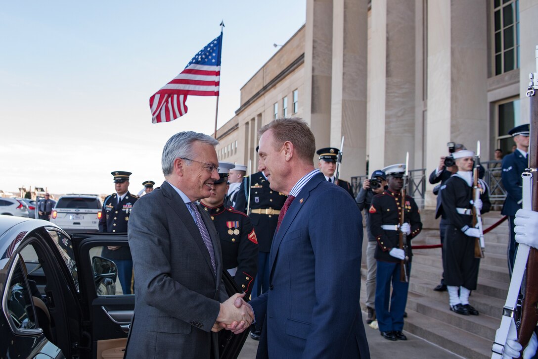 Two defense leaders shake hands at the Pentagon.