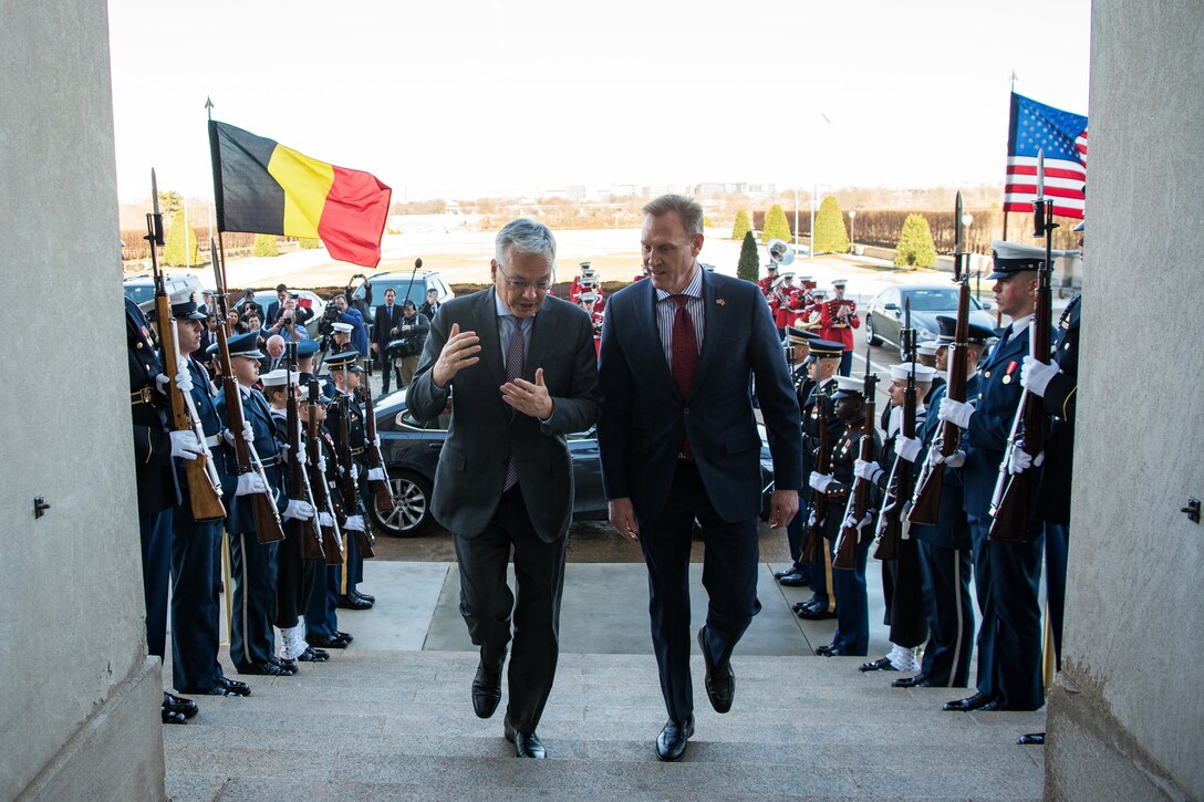 Two defense leaders walk up the steps at the Pentagon.
