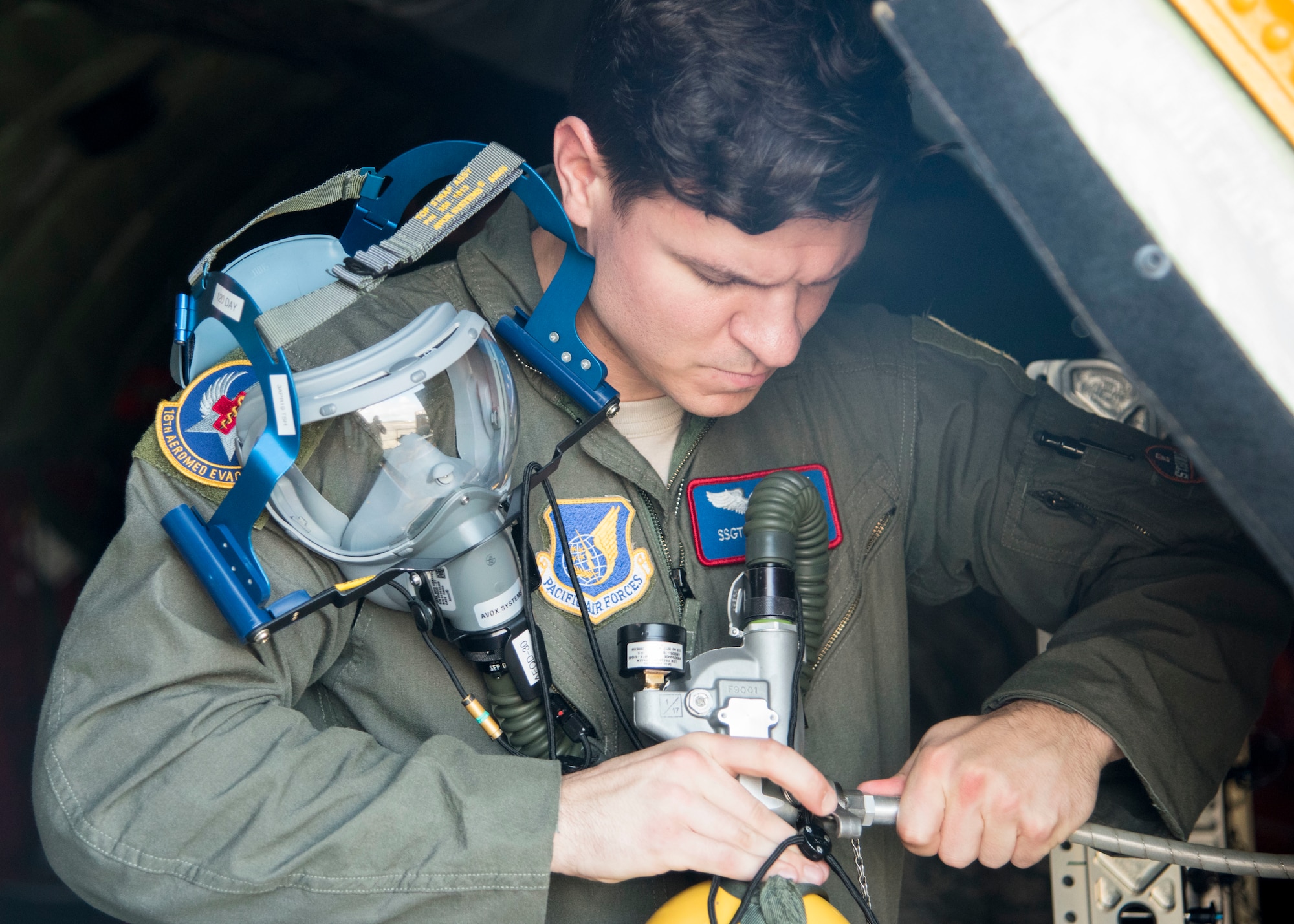 U.S. Air Force Staff Sgt. Dylan King, 18th Aeromedical Evacuation Squadron AE technician, charges an emergency respirator air tank aboard a 384th Air Refueling Squadron KC-135 Stratotanker during an AE exercise near Kadena Air Base, Japan, Feb. 19, 2019. Airmen of the 18th AES rely on practice sorties with flying units like the 384th Air Refueling Squadron to hone their mission-essential skills. (U.S. Air Force photo by Senior Airman Ryan Lackey)