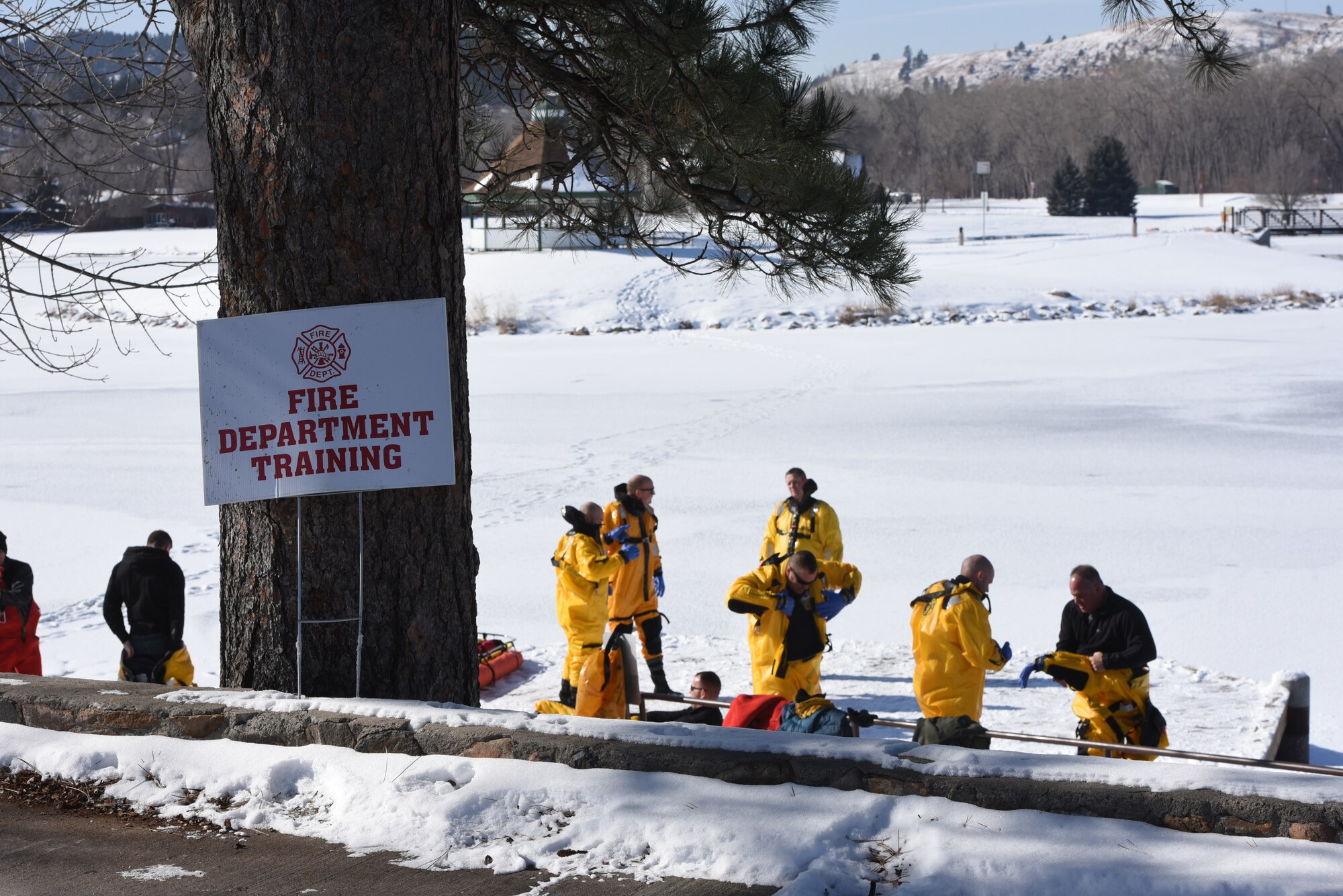 Airmen from the 28th Civil Engineer Squadron Fire Protection Flight don Mustang Ice Commander suits before heading out on the ice at Canyon Lake in Rapid City, S.D., Feb. 12, 2019. The suits are made of durable urethane-coated nylon shelland a removable buoyancy liner, which provides additional thermal protection. (U.S. Air Force photo by Senior Airman Michella Stowers)