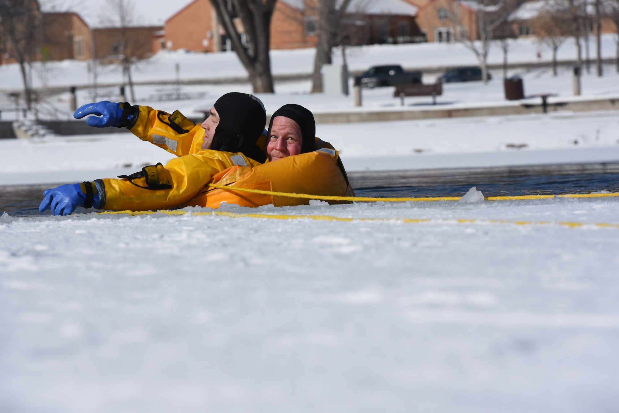 Hunter Harlan, a Rapid City Fire Department ice rescue instructor, demonstrates how to save someone who has fallen into ice water at Canyon Lake in Rapid City, S.D., Feb. 12, 2019. The instructors stressed the importance of not only keepingcalm during an ice water emergency but also making sure the rescuers protect themselves and control the situation. (U.S. Air Force photo by Senior Airman Michella Stowers)