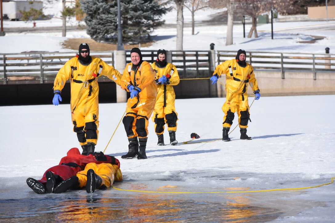 Airmen from the 28th Civil Engineer Squadron Fire Protection Flight practice performing an ice rescue at Canyon Lake in Rapid City, S.D., Feb. 12, 2019. While one Airman goes into the water to rescue the patron, it takes a team workingtogether to successfully perform an ice water rescue. (U.S. Air Force photo by Senior Airman Michella Stowers)