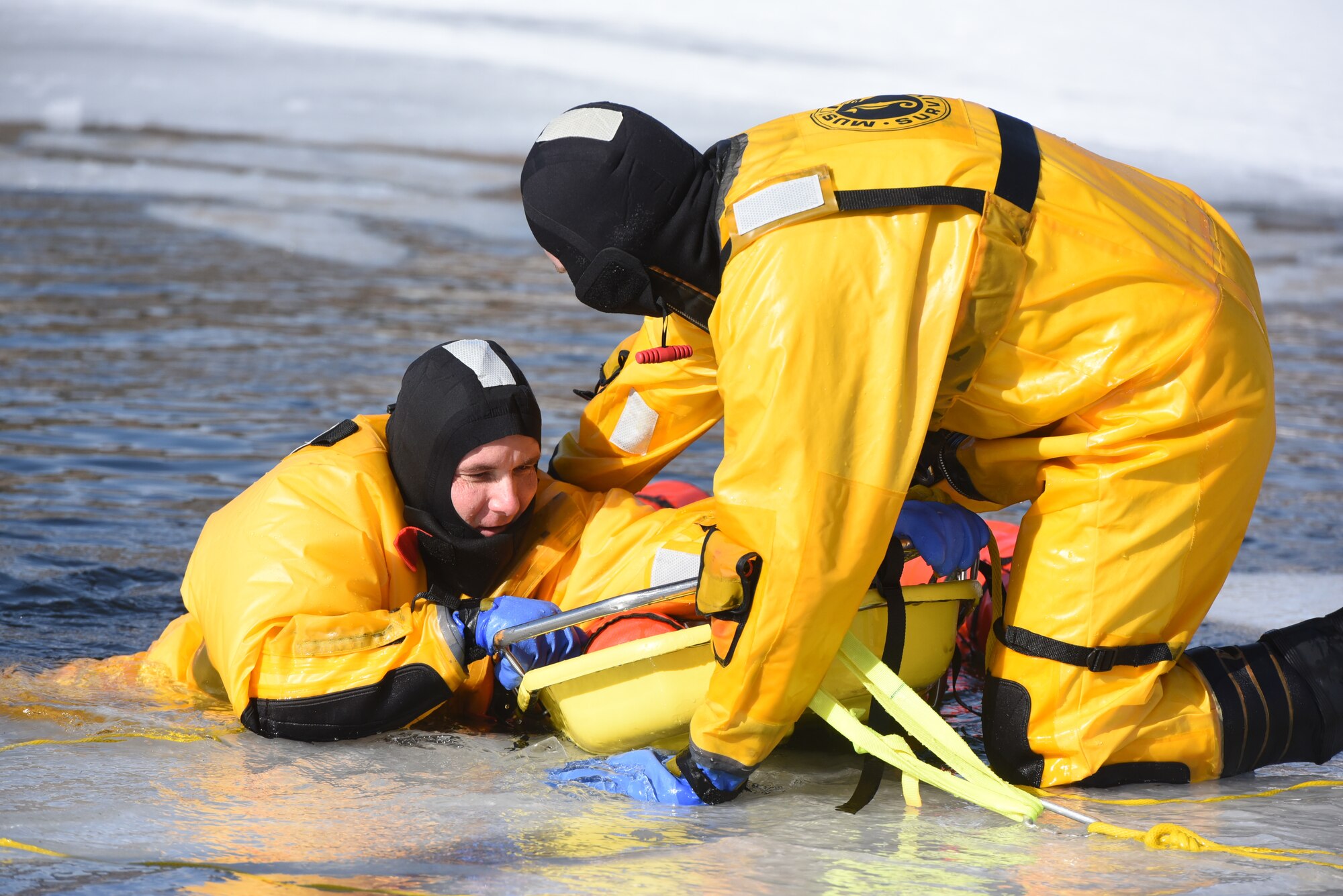 Airmen from the 28th Civil Engineer Squadron Fire Protection Flight practice ice water rescue techniques at Canyon Lake in Rapid City, S.D., Feb. 12, 2019. One of the techniques practiced did not require the firefighter to get into thewater with the person they wished to save. This is one way that the rescuer is able to not only maintain their own safety but also control the situation. (U.S. Air Force photo by Senior Airman Michella Stowers)