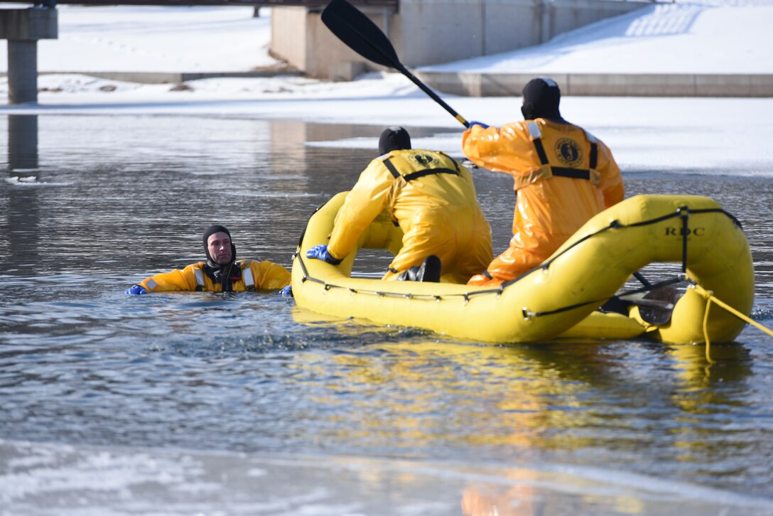Airmen from the 28th Civil Engineer Squadron Fire Protection Flight practice using a rapid deployment craft in order to perform “rescues” during training at Canyon Lake in Rapid City, S.D., Feb. 12, 2019. Although a team of two is on thecraft, there’s still a four-to five-man team on the ice nearby ready to pull them back to safety. (U.S. Air Force photo by Senior Airman Michella Stowers)