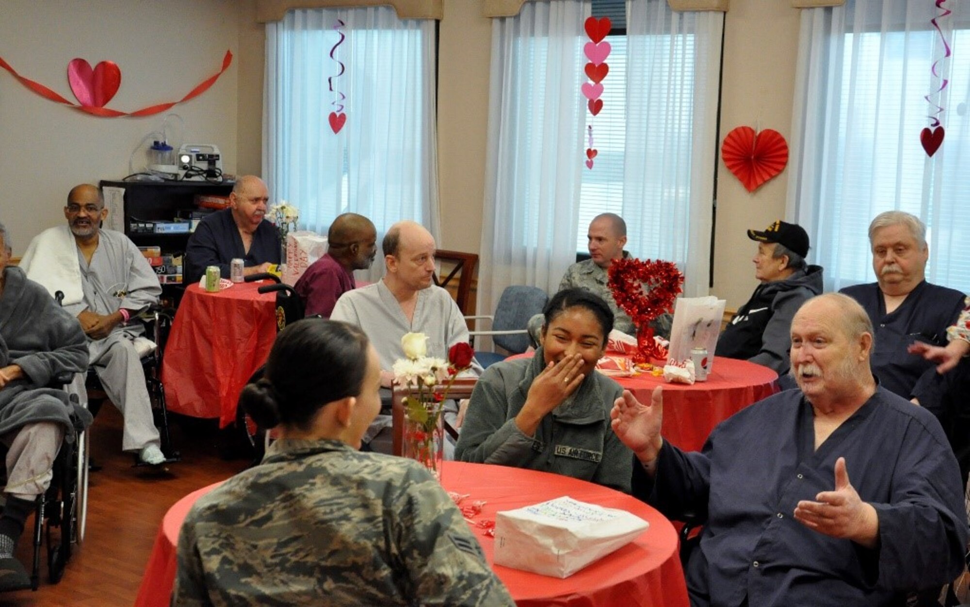 Airmen laugh and exchange stories with veterans at the Dayton Veterans Affairs Medical Center, Dayton, Ohio, Feb. 14, 2019.