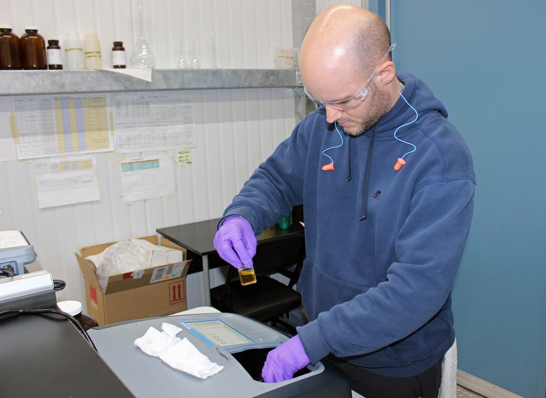 Ben Orchard, environmental engineer and pilot operator with CDM Smith, handles water samples inside the Advanced Treatment Pilot Study trailer at the McMillan Water Treatment Plant, Washington Aqueduct, District of Columbia, Dec. 19, 2018. (U.S. Army photo by Sarah Lazo)