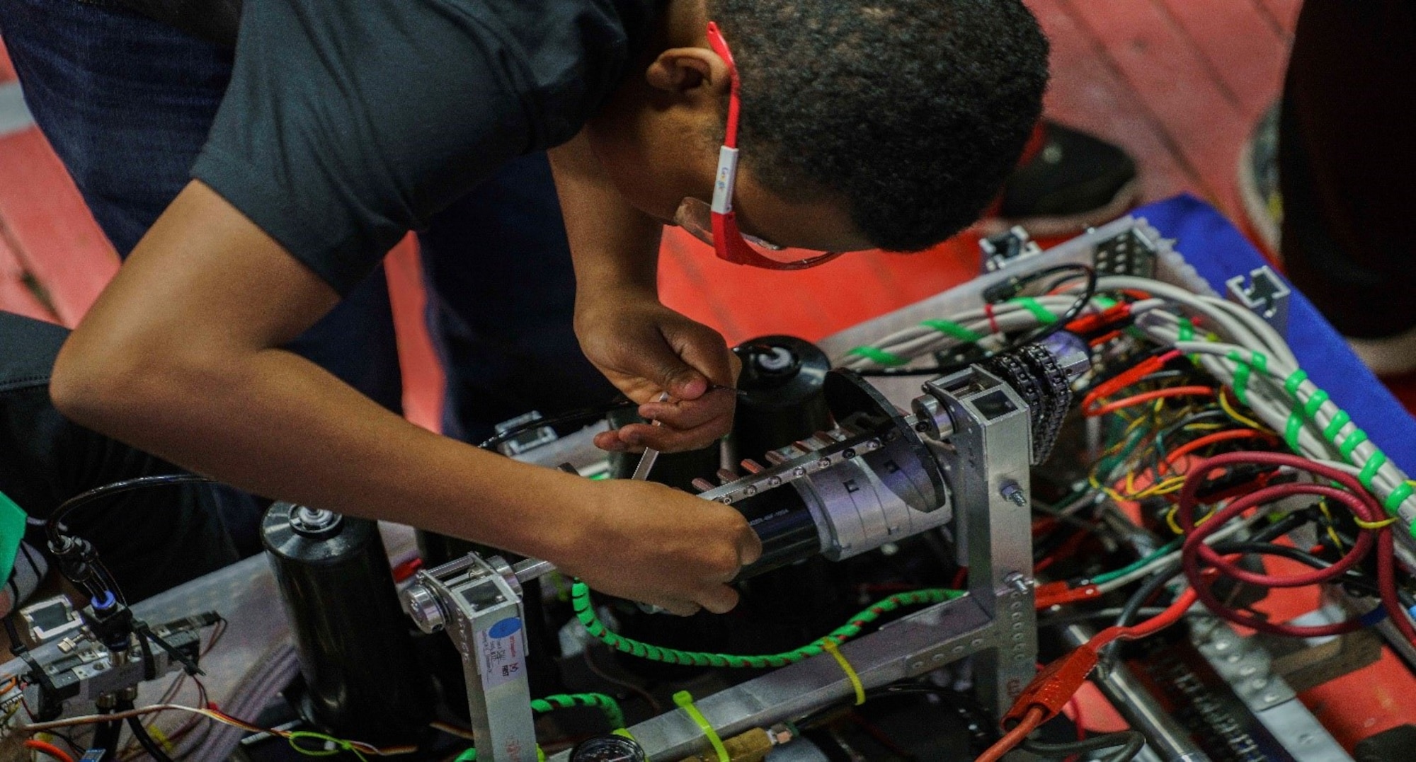 A student fine tunes a robot in preparation for the next match.   The Wright-Patterson Air Force Base Education Outreach Office works with the FIRST Robotics Competition where high school students strategize, prototype, manufacture, assemble and program a 125-pound robot in only six weeks. This program not only supports education in science, technology, engineering and math, but improves aware of opportunities to pursue STEM fields. (U.S. Air Force photo/Kwame Acheampong)