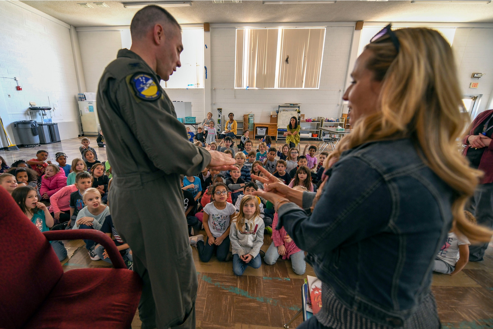 Col. Joseph Campo, 49th Wing commander, and his wife, Sarah Campo, play a game of ‘rock, paper, scissors’ in front of Holloman Elementary School students, Feb. 21, 2019, on Holloman Air Force Base, N.M. Campo read to the children as he was selected as this month’s ‘mystery reader.’ (U.S. Air Force photo by Staff Sgt. Christine Groening)