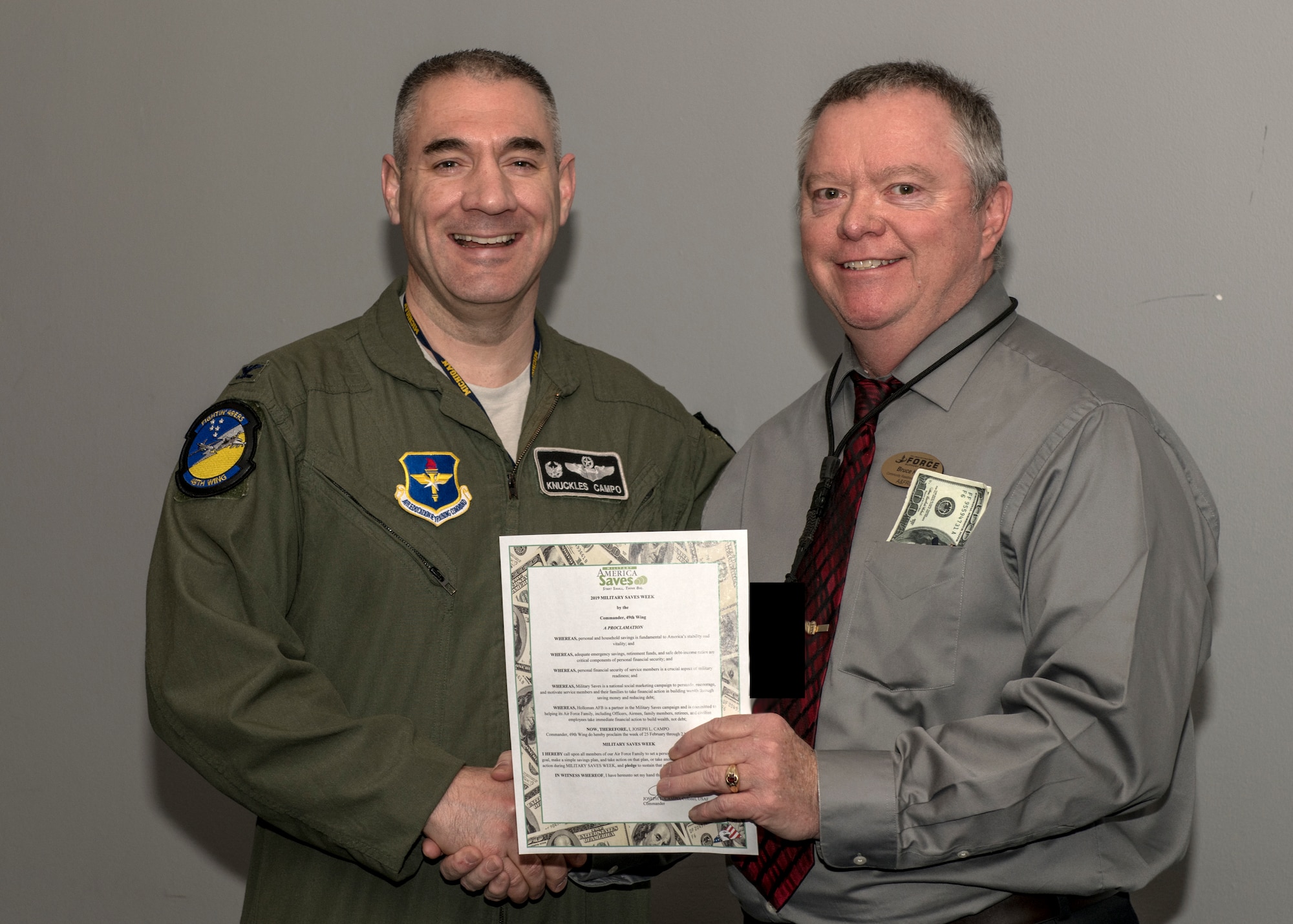 Col. Joseph Campo, 49th Wing commander, poses for a photo with Bruce Knee, 49th Force Support Squadron’s Airman and Family Readiness Center community readiness consultant and personal financial manager, Feb. 20, 2019, on Holloman Air Force Base, N.M. Campo signed the Military Saves Week 2019 proclamation, kick starting an educational week of financial readiness and success. (U.S. Air Force photo by Airman 1st Class Kindra Stewart)