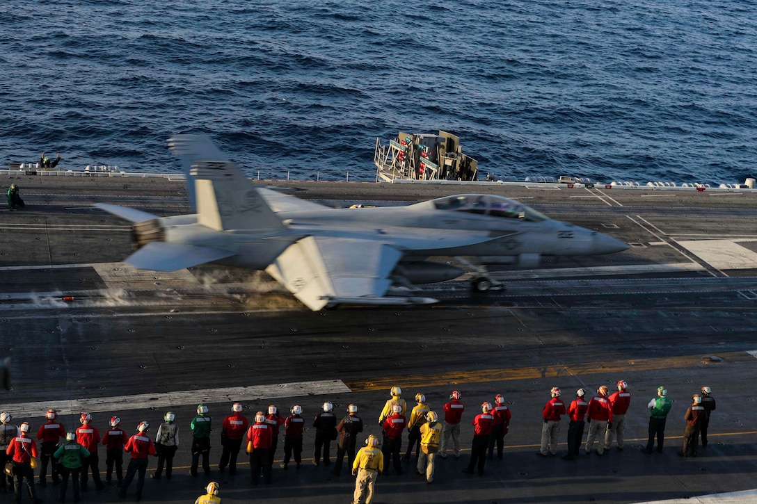 A jet takes off the flight deck of a ship.