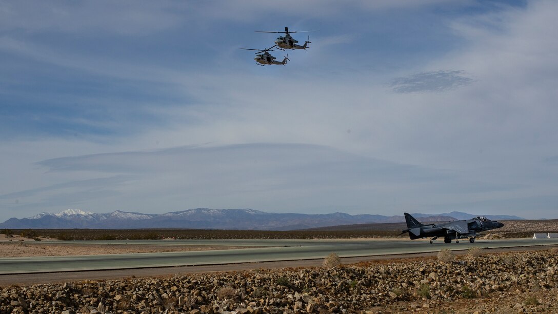 Two UH-1Y's  with Marine Light Attack Helicopter Squadron (HMLA) 369, Marine Aircraft Group (MAG) 39, 3rd Marine Aircraft Wing (MAW) fly over an AV-8B Harrier with Marine Attack Squadron (VMA) 311, MAG-13, at Marine Corps Air Ground Combat Center Twentynine Palms, Calif., Feb. 15 in an epic display of combat power.  Over the course of several hours, more than 100 aircraft from MAG-13 and MAG-39  took to the skies over Southern California highlighting their ability to provide aviation support on an enormous scale, proving 3rd MAW's capability to "Fix, Fly, Fight" and, when needed, advance at a moment's notice. (U.S. Marine Corps photo by Sgt. David Bickel)