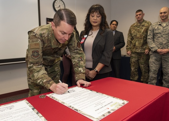 U.S. Air Force Col. Jeffrey Nelson, 60th Air Mobility Wing commander, signs a proclamation designating Feb. 25 through March 1, 2019 Military Saves Week at the Airman and Family Readiness Center, Feb. 21, 2019, Travis Air Force Base, California. The Military Saves Week program encourages Airman to save for the future and to reduce debt. The event is a team effort between the A&FRC, Travis Credit Union and Armed Forces Bank. (U.S. Air Force Photo by Heide Couch)
