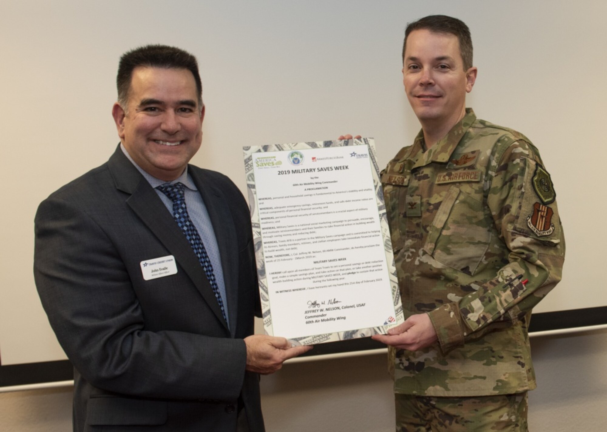 John Evalle, left,Travis Credit Union Military Affairs Officer and U.S. Air Force Col. Jeffrey Nelson, 60th Air Mobility Wing commander, pose with a proclamation designating Feb. 25 through March 1, 2019 Military Saves Week at the Airman and Family Readiness Center, Feb. 21, 2019, Travis Air Force Base, California. The Military Saves Week program encourages Airman to save for the future and to reduce debt. The event is a team effort between the A&FRC, Travis Credit Union and Armed Forces Bank. (U.S. Air Force Photo by Heide Couch)