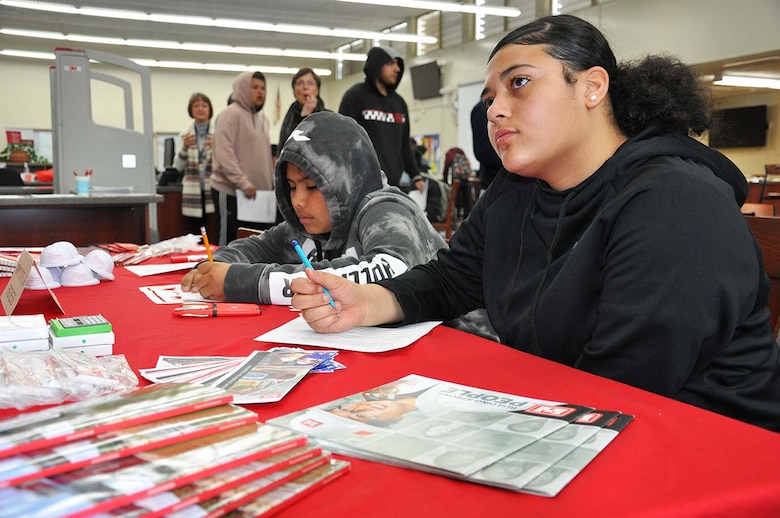 John Muir High School ninth-graders Ambur Germain and Christopher Bustillo listen to representatives from the U.S. Army Corps of Engineers speak about their careers during the school’s Engineering and Environmental Science Academy Career Exploration Showcase Feb. 13 in the school’s library in Pasadena, California.