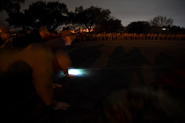 Hundreds of Special Tactics Airmen, trainees, and supporters perform memorial pushups to kick off the Special Tactics Memorial March Feb. 22, 2019, at Lackland Air Force Base, Texas.