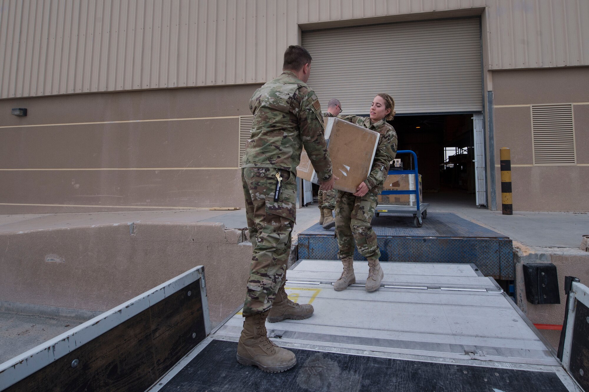Senior Airman Chelsey Burkus (right), and Senior Airman Bill Tilton, both 379th Expeditionary Logistics Readiness Squadron (ELRS) traffic management office (TMO) traffic management journeymen, manually move boxes Feb. 22, 2019, at Al Udeid Air Base, Qatar. The 379th ELRS TMO handles the pick-up, storage, shipment, and delivery of assets such as small vehicle parts, aircraft engines, and clothing items throughout the U.S. Central Command area of responsibility. (U.S. Air Force photo by Tech. Sgt. Christopher Hubenthal)