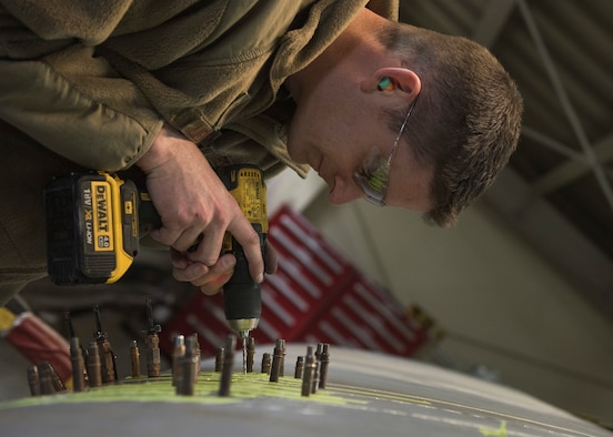 Master Sgt. Andrew Liederbach, 386th Expeditionary Maintenance Squadron combat metals flight chief, inserts temporary placeholders where the rivits will be placed after the permanent patch is complete at an undisclosed location in Southwest Asia, Feb. 6, 2019. When the damage first occurred, Liederbach and his team got their tools and materials together to fly to the aircraft to place a temorary patch on the wing to get it back to base for a permanent repair.