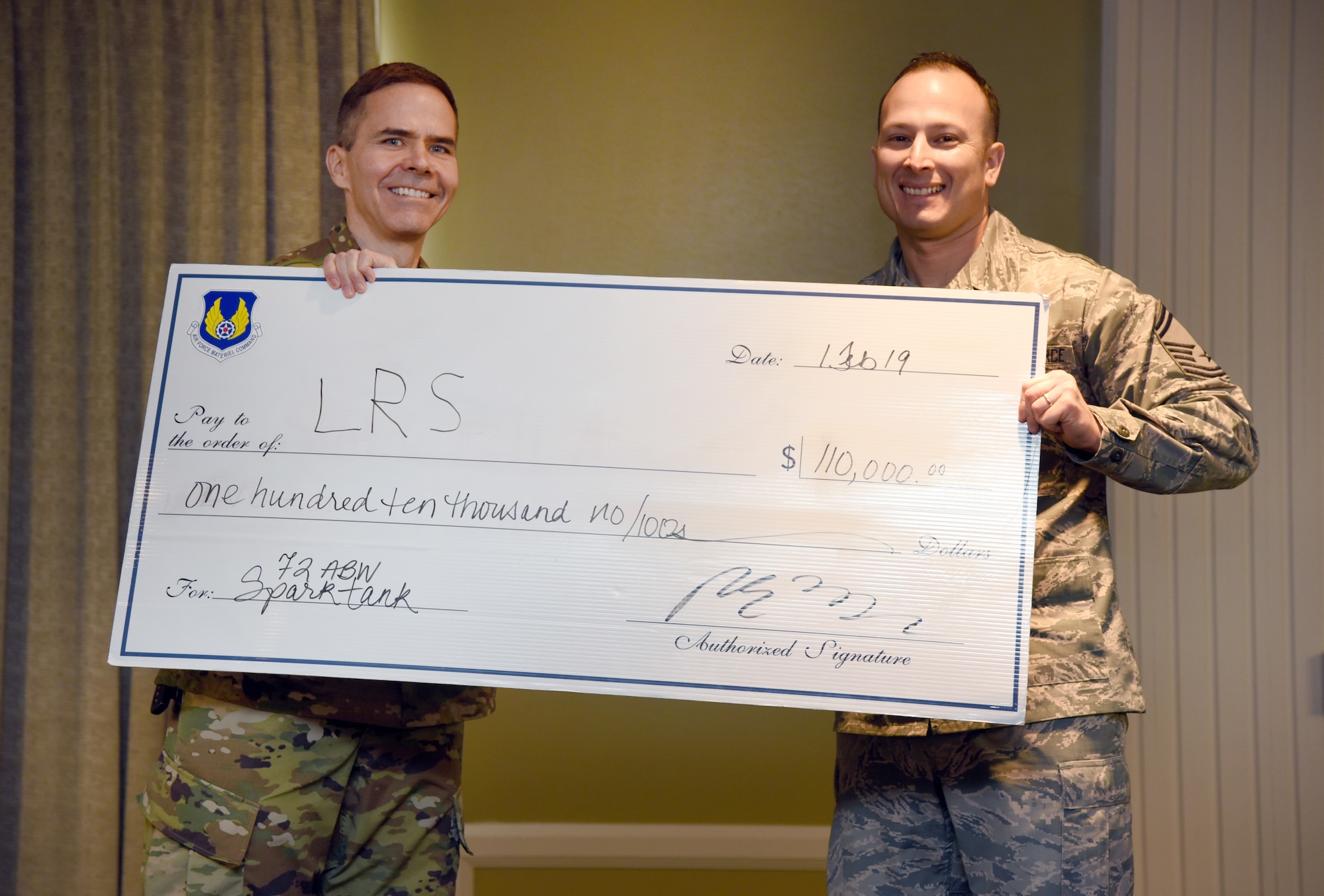 Col. Ralph Taylor, 72nd Air Base Wing vice commander, left, presented Senior Master Sgt. Francisco Zamorano with the top prize in the Spark Tank competition Feb. 1.