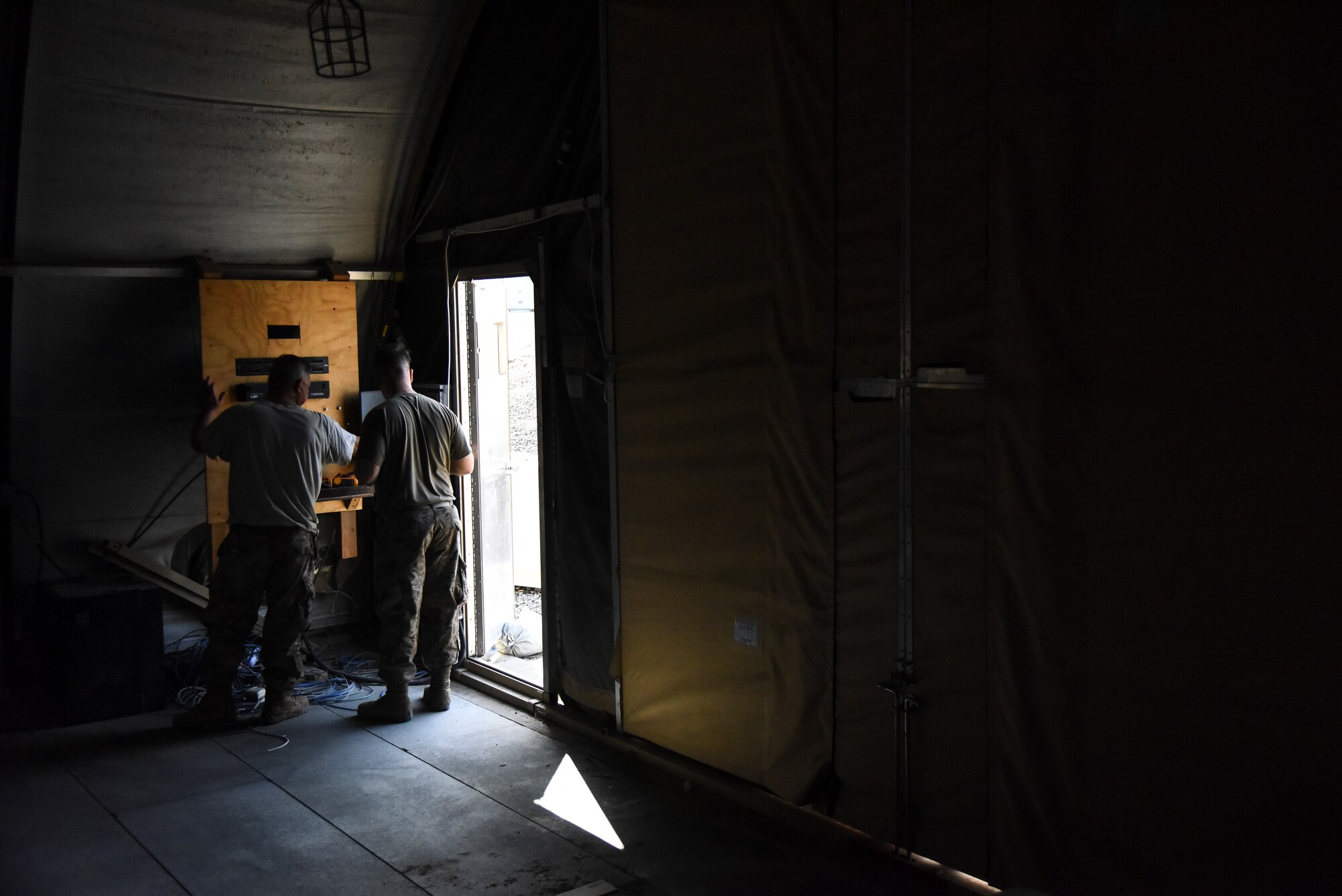 Senior Airmen Michael Young and Zachary Ford, 380th Expeditionary Civil Engineer Squadron electrical systems journeymen, troubleshoots a light switch at Al Dhafra Air Base, United Arab Emirates, Feb. 18, 2019. Electrical systems specialists Installs, maintains, and repairs cathodic protection and grounding systems, and voltage and current regulators. (U.S. Air Force photo by Senior Airman Mya M. Crosby)