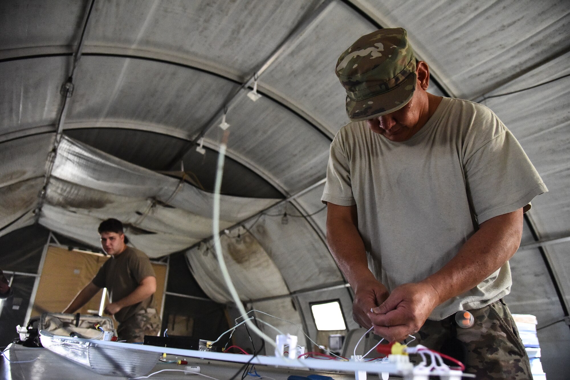 Senior Airmen Michael Young Zachary Ford, 380th Expeditionary Civil Engineer Squadron electrical systems journeymen, wire ballasts at Al Dhafra Air Base, United Arab Emirates, Feb. 18, 2019. Electrical systems specialists troubleshoot malfunctions using technical orders, manufacturers' handbooks, local procedures, codes, and directives.  (U.S. Air Force photo by Senior Airman Mya M. Crosby)