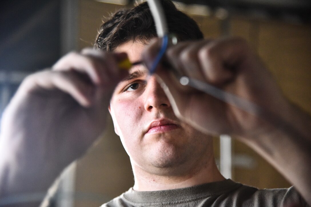 Senior Airman Zachary Ford, 380th Expeditionary Civil Engineer Squadron electrical systems journeymen, connects power to a light fixture at Al Dhafra Air Base, United Arab Emirates, Feb. 18, 2019. Electrical systems specialists troubleshoot malfunctions using technical orders, manufacturers' handbooks, local procedures, codes, and directives.  (U.S. Air Force photo by Senior Airman Mya M. Crosby)