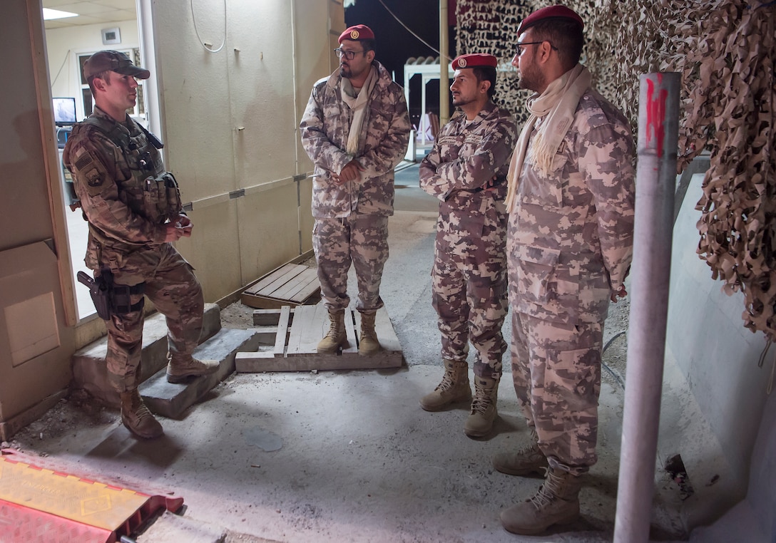 Master Sgt. Jordan Barnes, left, 379th Expeditionary Security Forces Squadron (ESFS) combined response joint patrol leader, talks to members of the Qatar Military Police (QMP), during a “Spartan Patrol” Jan. 17, 2019, at Al Udeid Air Base, Qatar. Barnes works side-by-side with the QMP to conduct the patrols, which check for vulnerabilities in the installation’s perimeter. Barnes aims to perform one patrol a night to provide security and build the partnership between U.S. Air Force and Qatar Armed Forces.  (U.S. Air Force photo by Tech. Sgt. Christopher Hubenthal)
