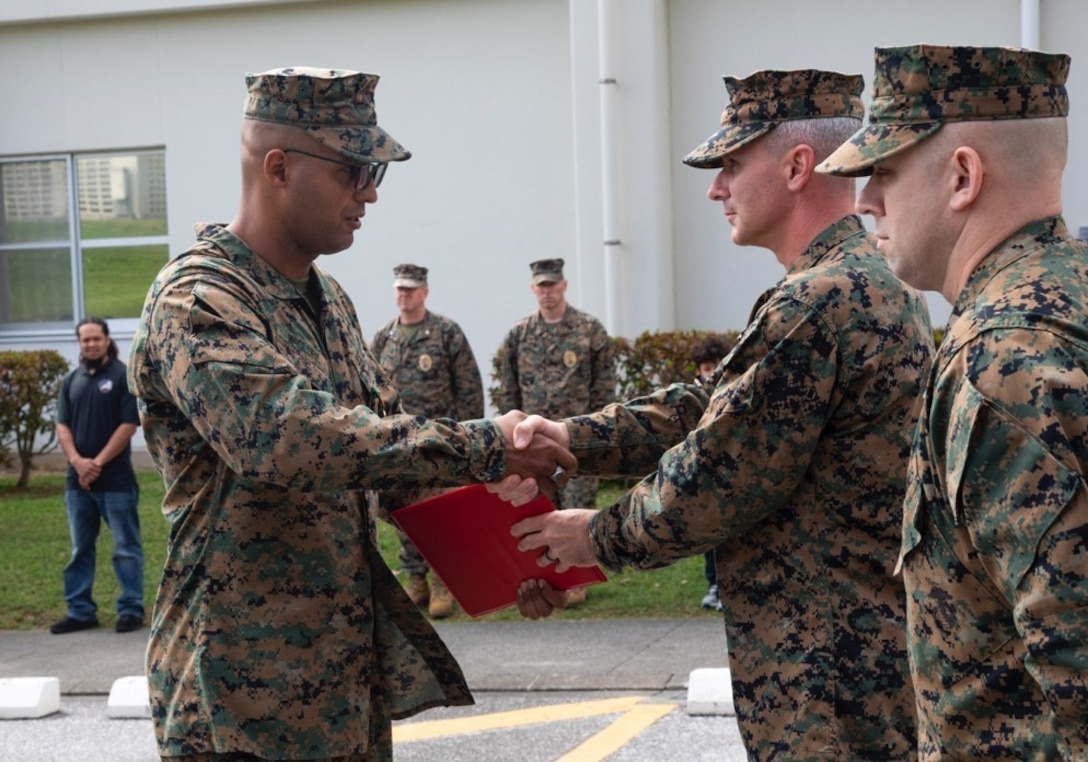 Col. Vincet Ciccoli, right, awards Staff Sgt. Jonathan McClure, left, a Navy Achievement Medal February 22, 2019, at Camp Foster, Okinawa, Japan. McClure was awarded the Navy Achievement Medal for superior performance of duty while serving as a military policeman and accident investigation section chief Provost Marshal’s office, H&S Bn, MCIPAC-MCB. With quick thinking and a bias for action, McClure rescued a woman from choking at a local restaurant.