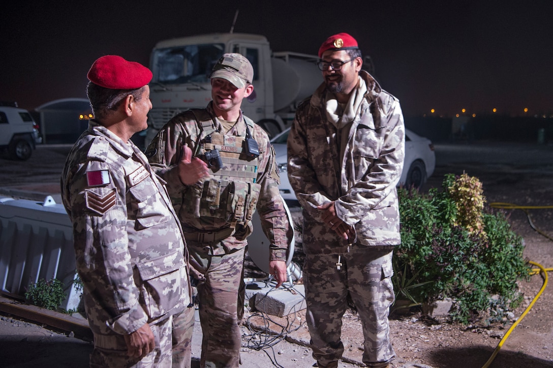 Master Sgt. Jordan Barnes, center, 379th Expeditionary Security Forces Squadron (ESFS) combined response joint patrol leader, talks to Qatar Military Police (QMP) Sgt. Saad Ahmed Al-Hubabi, left, during a “Spartan Patrol” Jan. 17, 2019, at Al Udeid Air Base, Qatar. Barnes works side-by-side with the QMP to conduct the patrols, which check for vulnerabilities in the installation’s perimeter. Barnes aims to perform one patrol a night to provide security and build the partnership between U.S. Air Force and Qatar Armed Forces.  (U.S. Air Force photo by Tech. Sgt. Christopher Hubenthal)
