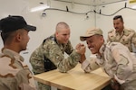 U.S. Army Staff Sgt. David Johnson, the powertrain shop chief assigned to B Company, 935th Aviation Support Battalion, Illinois Army National Guard, arm wrestles with an Iraqi aviation engineer during a break from organizing the portable maintenance shop containers at an Iraqi hangar at Camp Taji Military Complex, Oct. 1, 2018.  The Iraqi Air Enterprise will ultimately provide Iraq with the self-sufficient air capabilities required by a sovereign nation to protect its borders and defeat internal threats.