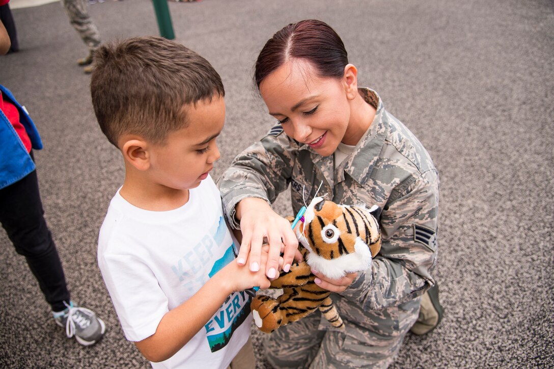Senior Airman Shinique Manders, 23d Aeromedical Dental Squadron, helps a child use a toothbrush during a visit to the Child Development Center, Feb. 22, 2019, at Moody Air Force Base, Ga. February is National Children's Dental Health Month, a national health observance that brings together thousands of dedicated professionals, healthcare providers and educators to promote the benefits of good oral health to children. (U.S. Air Force Photo by Andrea Jenkins)
