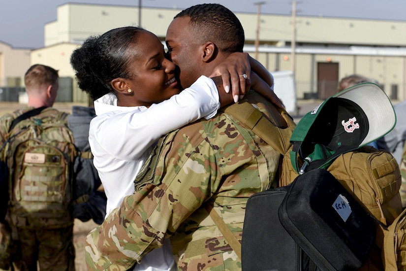 An airman hugs his wife.