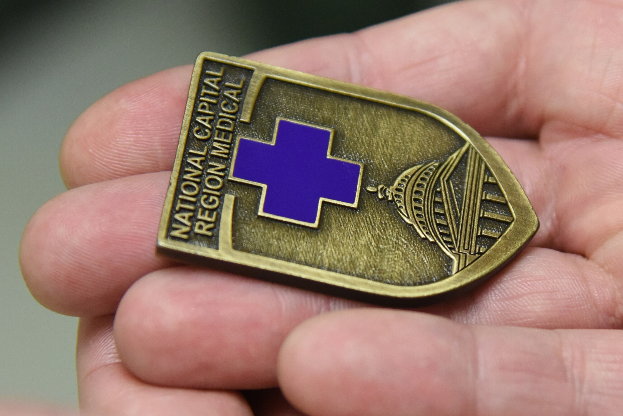 U.S. Air Force Capt. Thomas Ross, 81st Inpatient Operation Squadron officer in charge, displays a coin presented to him by U.S. Army Maj. Gen. Ronald Place, Defense Health Agency, director for the National Capital Region Medical Directorate and Transition Intermediate Management Organization, during an immersion tour inside the Keesler Medical Center at Keesler Air Force Base, Mississippi, Feb. 13, 2019. The purpose of Place's two-day visit was to become more familiar with the medical center's mission capabilities and to receive the status of the 81st Medical Group's transition under DHA. (U.S. Air Force photo by Kemberly Groue)