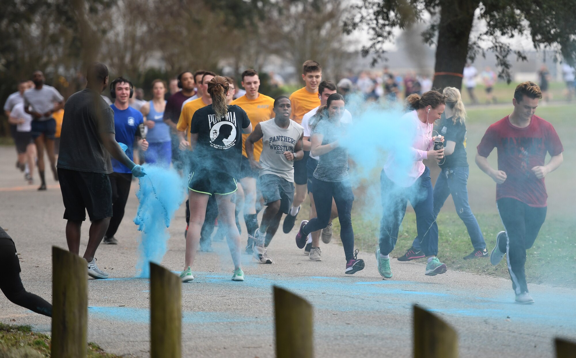Keesler personnel get colored powder thrown at them during a Run For Your Life Color Run 5K through marina park at Keesler Air Force Base, Mississippi, Feb. 21, 2019. The event, which was held in support of suicide prevention awareness, allowed participants to detour from the course and get showered with different colored powders as it was tossed in the air. A portion of the t-shirt sale proceeds will be donated to the American Foundation for Suicide Prevention and the Keesler Airman's Ball. (U.S. Air Force photo by Kemberly Groue)