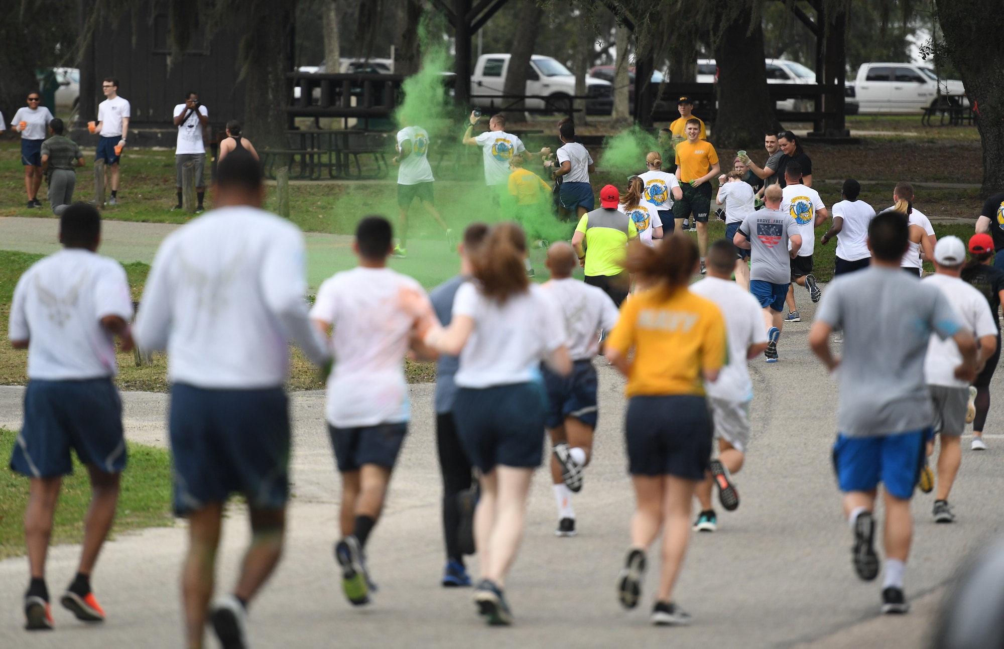 Keesler personnel get colored powder thrown at them during a Run For Your Life Color Run 5K through marina park at Keesler Air Force Base, Mississippi, Feb. 21, 2019. The event, which was held in support of suicide prevention awareness, allowed participants to detour from the course and get showered with different colored powders as it was tossed in the air. A portion of the t-shirt sale proceeds will be donated to the American Foundation for Suicide Prevention and the Keesler Airman's Ball. (U.S. Air Force photo by Kemberly Groue)
