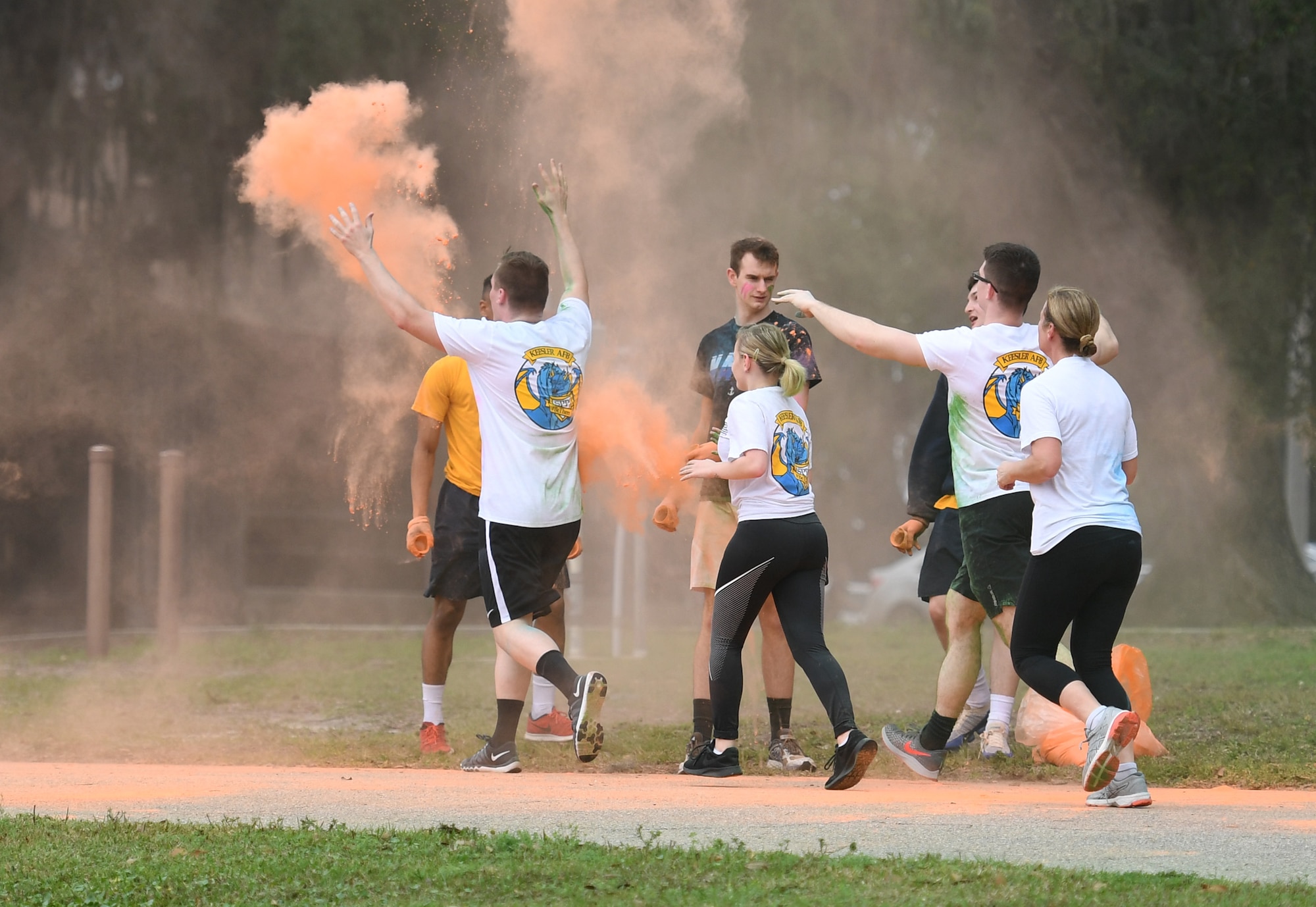 Keesler personnel get colored powder thrown at them during a Run For Your Life Color Run 5K through marina park at Keesler Air Force Base, Mississippi, Feb. 21, 2019. The event, which was held in support of suicide prevention awareness, allowed participants to detour from the course and get showered with different colored powders as it was tossed in the air. A portion of the t-shirt sale proceeds will be donated to the American Foundation for Suicide Prevention and the Keesler Airman's Ball. (U.S. Air Force photo by Kemberly Groue)