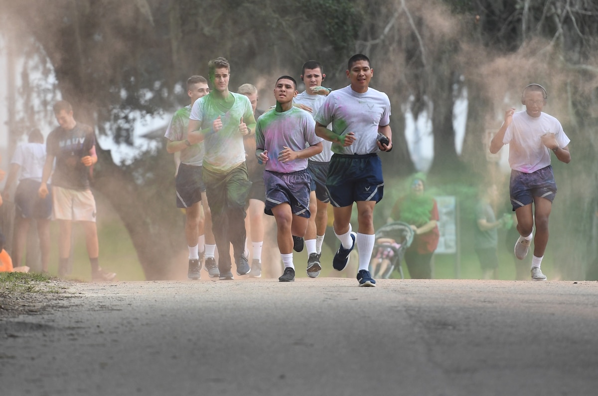 Airmen from the 338th Training Squadron and other Keesler personnel get colored powder thrown at them during a Run For Your Life Color Run 5K through marina park at Keesler Air Force Base, Mississippi, Feb. 21, 2019. The event, which was held in support of suicide prevention awareness, allowed participants to detour from the course and get showered with different colored powders as it was tossed in the air. A portion of the t-shirt sale proceeds will be donated to the American Foundation for Suicide Prevention and the Keesler Airman's Ball. (U.S. Air Force photo by Kemberly Groue)